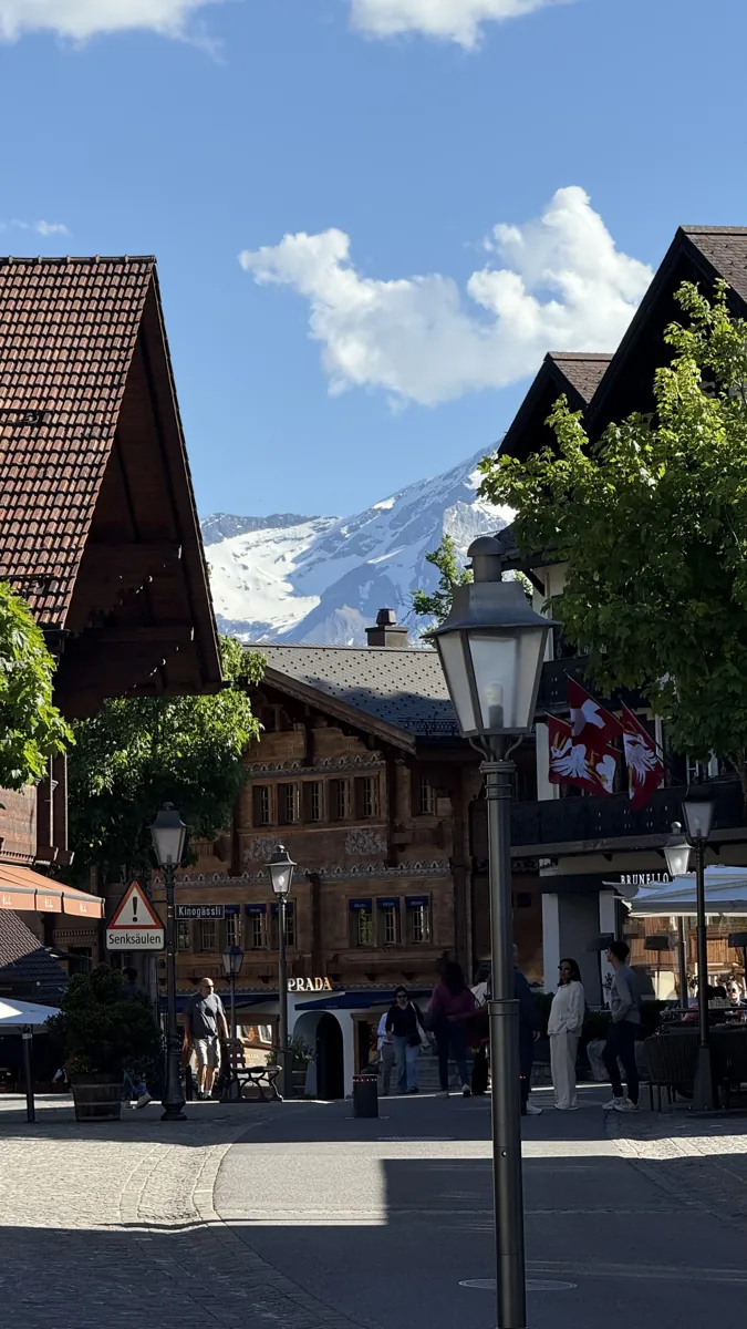 Rua de Gstaad com chalés de madeira e uma lanterna de ferro