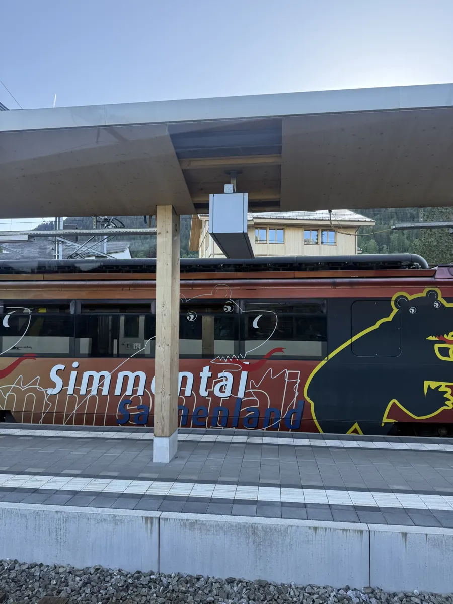 Trem da região do Simmental parado numa plataforma, na mesma linha do GoldenPass