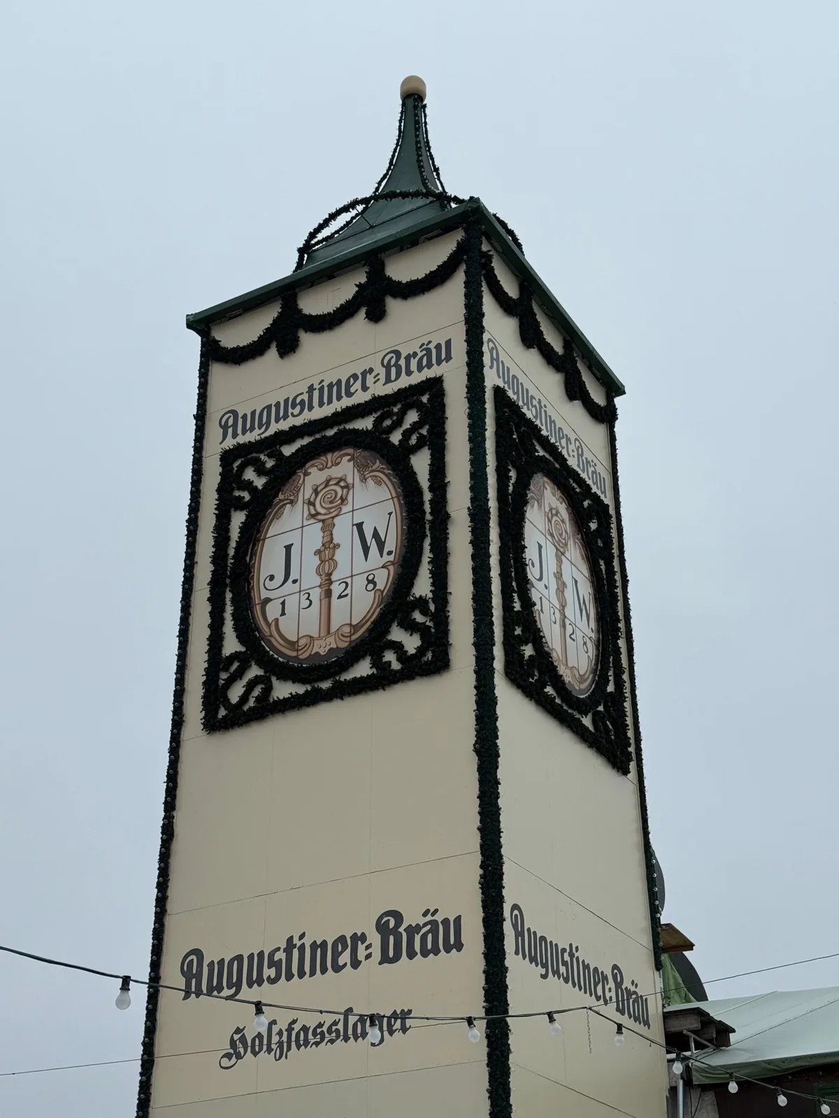 A torre de 30 metros da Augustiner-Festhalle, com a inscrição "Holzfasslager" na base: é ali que ficam os barris de madeira. Foto minha, setembro de 2026.
